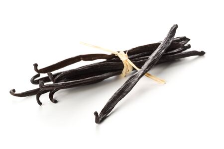 Bundle of tied, dried bourbon vanilla beans or pods over white background - selective focusの写真素材