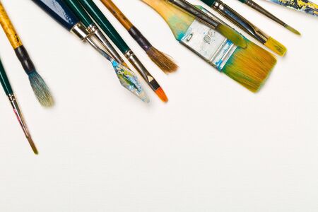 Artistic art supply utensils with paintbrushes on white background with copy space flat lay top view from aboveの写真素材