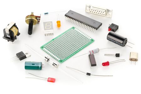 Different electronic parts or components on white background with resistors, capacitors, diode and ic chips, selective focus