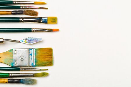 Artistic art supply utensils with paintbrushes on white background with copy space flat lay top view from aboveの写真素材