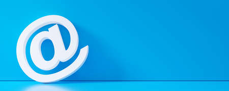 White e-mail at symbol leaning against blue wall in room with blue floor background banner, contact...