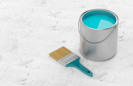 Paintbrush with silver paint bucket with cyan paint on white wooden floor background, home...