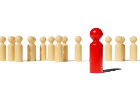 Single red wood figure standing out from a group of brown wood figures, leadership, standing out or...