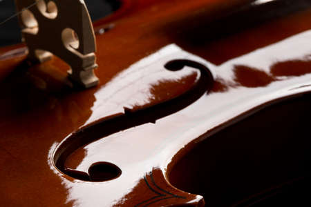 Close up macro of F hole on brown wooden fiddle or violin, classic musical instrument, over black background, selective focusの写真素材