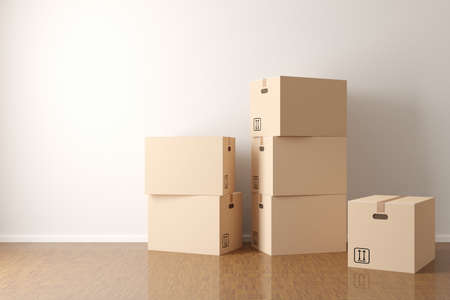 Brown moving storage cardboard boxes stacked in empty room in apartment or house with wooden floor...