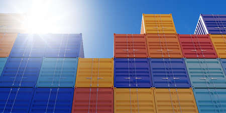 Stacked industrial intermodal cargo transport or shipping containers storage outside with blue sky...
