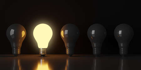 Single glowing light bulb in row of dark bulbs over black background, creativity, uniqueness or standing out concept, 3D illustrationの写真素材