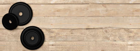 Fitness gym weight plates stack over wooden floor background flat lay top view from above, muscle exercise, bodybuilding or fitness concept, 3D illustrationの写真素材