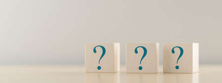 Three wooden blocks or cubes with question mark symbol icons on wooden table, faq, questions or support concept, 3D illustrationの写真素材