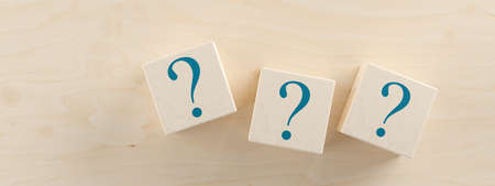 Three wooden blocks or cubes with question mark symbol icons on wooden table, faq, questions or...