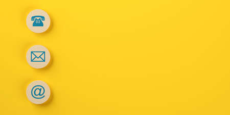 Wooden round telephone, envelope letter and e-mail symbols in a row on yellow background flat lay top view from above with copy space, contact us symbols or banner, 3D illustrationの写真素材