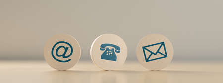 Wooden round telephone, envelope letter and e-mail symbols in a row on wooden table background,...
