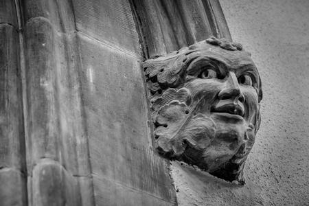 This is a picture of a face carved out of stone which is part of a door surround In an old building in Irellandの写真素材