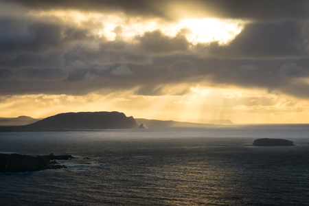 This is a picture of a sunset through rain clouds over the Donegal coast in Irelandの写真素材