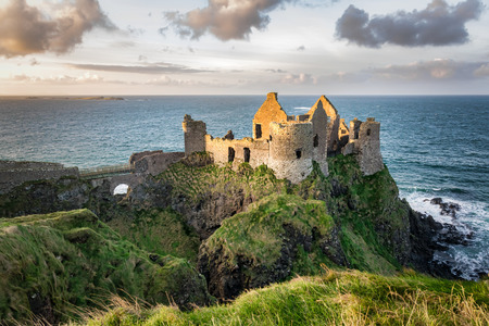 This is a picture of the ruins of Dunluce Castle in Northern Ireland.  It was built in the 13th century on the top of a sea cliff looking out to the Atlantic Oceanの写真素材