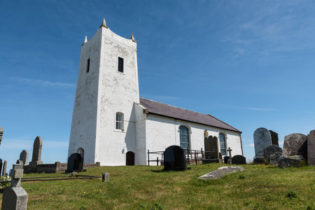 Ballintoy, Northern Ireland- Jun 20, 2020:The old Ballintoy Church of Ireland Church on the Antrim Coast in northern Ireland surrounded by an old grave yard and a farmers field.のeditorial素材