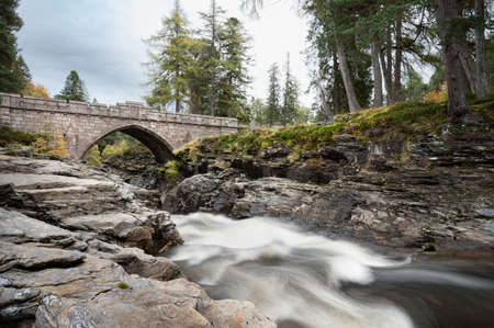 The stone bridge that goes over the rapids of the river Dee in the Cairngorms Mountains of Scotlandの写真素材