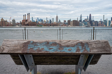 Wooden bench on a pier on New York City East river. Looking out on the Manhatten skyline.