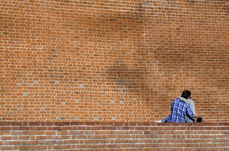 Couple in love kissing on a red brick wall