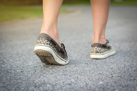 woman walking on road in parkの写真素材