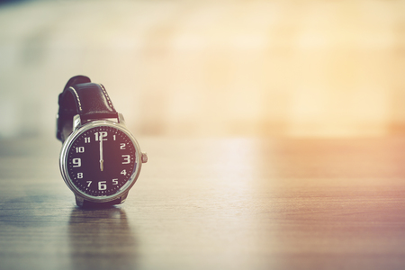 wristwatch on the table with blur bedroom background, the time show midday or midnightの写真素材