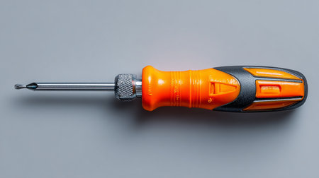 Screwdriver with orange handle isolated on grey background. Close up.の素材