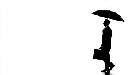 Silhouette of a businessman with an umbrella on a white backgroundの素材