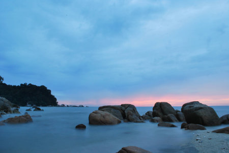 Seascape  The coastline with stones in the water at sunriseの写真素材