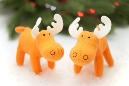 Two toy elks in artificial snow with pine on backgroundの写真素材