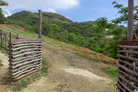 Open gate and road, hill landscape as backgroundの写真素材