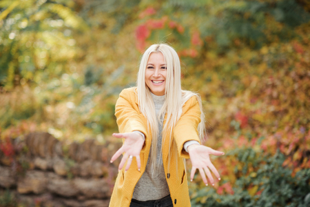 Fashion lifestyle portrait of young happy blond woman laughing and having fun in the city park at nice sunny day. bright fresh colorsの写真素材