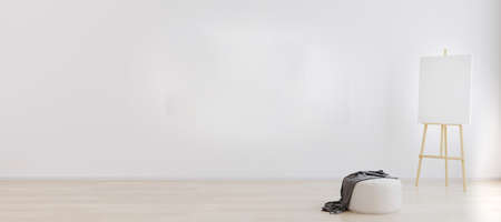 Easel with canvas in bright white room for mockup. Artist workspace concept. Empty bright room interior for mockup. Room with white wall and wooden flooring. 3d renderingの写真素材