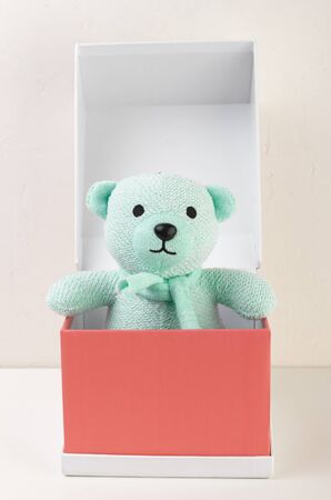 Turquoise bear toy in a red cardboard boxの写真素材