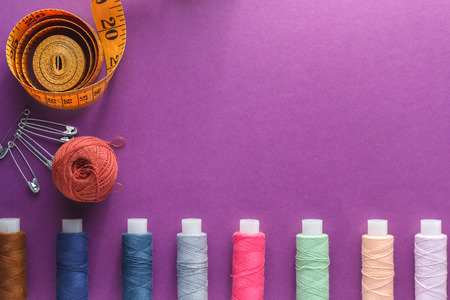 Multicolored Threads on a purple background with tailor tape measure.の写真素材
