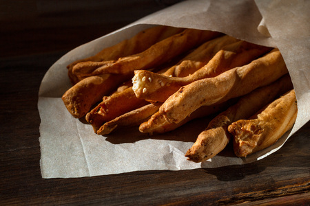 Traditional Italian snack, bread - grissini. On a dark stone table, top view, copy space.