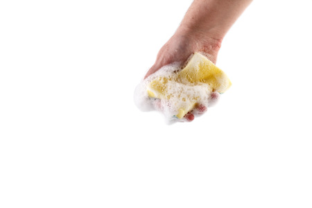 A sponge for washing dishes holds a hand on a white background isolate.の写真素材