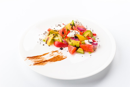 flying salad isolated on white background. Greek salad: red tomatoes, pepper, cheese, lettuce, cucumber, olives and olive oilの写真素材