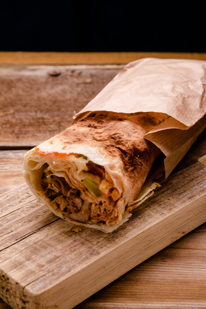 Doner Kebab Gyros Shawarma beef roll in pitta bread Wrap sandwich on wooden background. copy space.の写真素材