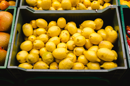 Bunch of lemons and oranges on boxes in supermarket,の写真素材