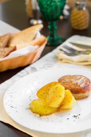 Fried minced pork cutlets with potatoes on dark wooden table.の写真素材