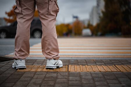 A man stands on the sidewalk by the roadの写真素材
