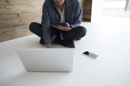 Men see the personal computer sitting on the floorの写真素材
