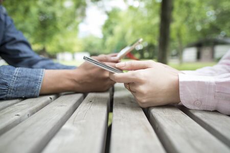 Couples View smartphone each in the park