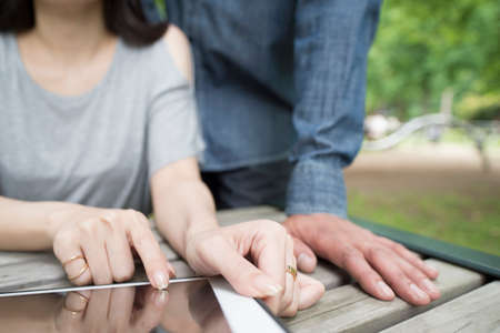 Couple that use the tablet in the park