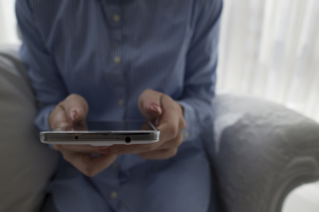 Female holding mobile phone.