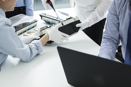 With computer repairman, an owner of small business. Monitors and other laptops in the background waiting for service.の写真素材