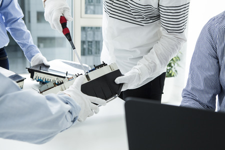 With computer repairman, an owner of small business. Monitors and other laptops in the background waiting for service.の写真素材