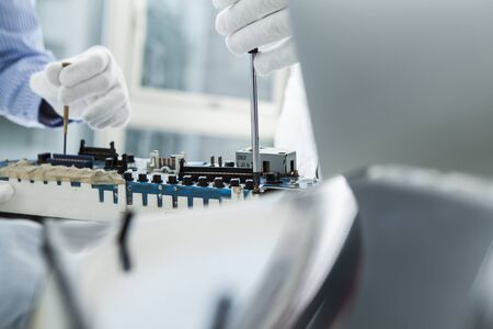 White and red cogs and wheels against businessman sitting on the floor using tabletの写真素材