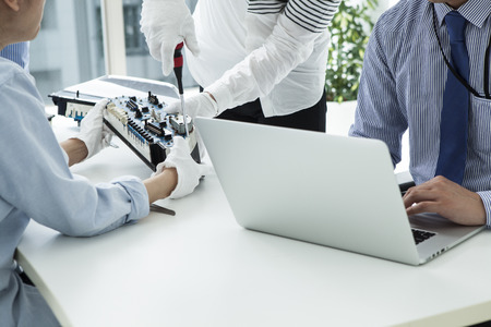 With computer repairman, an owner of small business. Monitors and other laptops in the background waiting for service.の写真素材