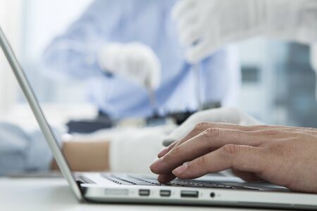With computer repairman, an owner of small business. Monitors and other laptops in the background waiting for service.の写真素材